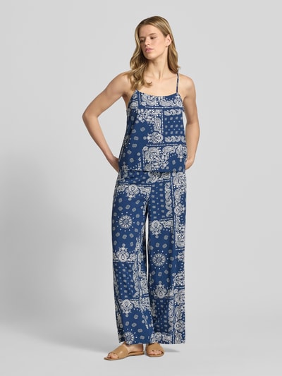 Frauenmodel trägt Relaxed Fit Weite Hose aus reiner Viskose Modell 'KAVI' von Only in Blau mit weißem Muster, Damen Weite Hose, Ganzkörperansicht von vorne.