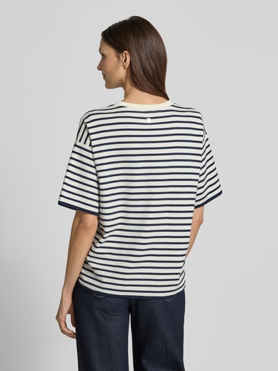 Frauenmodel trägt Boxy Fit Sweatshirt mit Rundhalsausschnitt Modell 'Tricia' von JOOP! aus Reiner Baumwolle, Querstreifen in Dunkelblau und Weiß, Ganzkörperansicht Rückansicht.