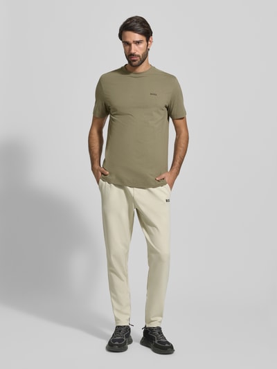 Męski model nosi Regular Fit T-Shirt aus Baumwoll-Mix od BOSS Green, oliwkowy, gładki, krótki rękaw, bawełniany miks, widok z przodu całości.
