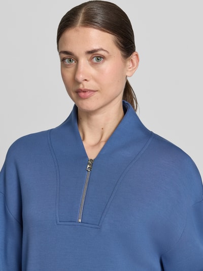 Vrouwenmodel draagt Sweatshirt aus Viskose-Mix mit Reißverschluss Modell 'davidson' van VARLEY, regular fit, V-hals, blauw, stretch, Nahaufnahme bovenlichaam.