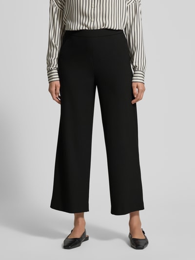 Frauenmodel trägt Wide Fit Schlupfhose mit Viskose-Anteil Modell 'Palina' von Raffaello Rossi in Schwarz mit Crêpe-Struktur, Ganzkörperansicht von vorne.