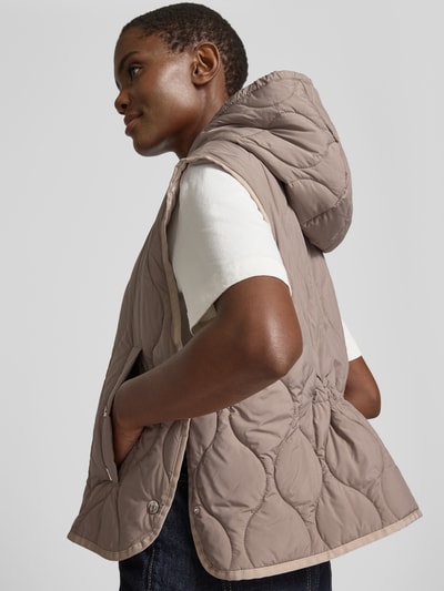 Frauenmodel trägt Steppweste mit Kapuze und Zweiwege-Reißverschluss von WHITE LABEL in Beige, strukturierte Oberfläche, Regular Fit, Eingrifftaschen, Rückenlänge 55 cm, Schulterbreite 50 cm, Brustweite 56 cm, Ganzkörperansicht Rückansicht.