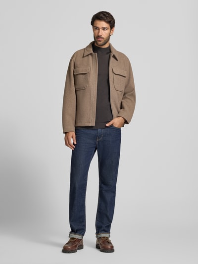 Męski model nosi Regular Fit Hemdjacke mit Brusttaschen Modell 'WAKEFIELD' od JACK & JONES Premium, brązowy odcień, prosty krój regular fit, kieszenie na piersi, kołnierz kent, zamek błyskawiczny, długość tyłu w rozmiarze M 66 cm, pełny widok z przodu.