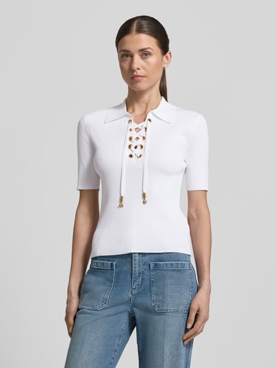 Vrouwenmodel draagt gebreid shirt met vetersluiting en platte kraag van MICHAEL Michael Kors, viscosemix met stretch, nauwsluitend model, V-hals met vetersluiting, fijnrib, labeldetails, voorkant volledig zichtbaar.