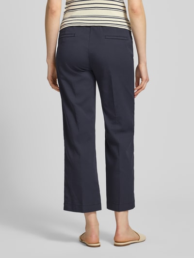 Frauenmodel trägt Wide Fit Stoffhose in 7/8-Länge Modell 'Sue' von TONI im Baumwoll-Mix mit Bügelfalten, Tunnelzug und Eingrifftaschen, dunkelblau, Ganzkörperansicht Rückansicht.