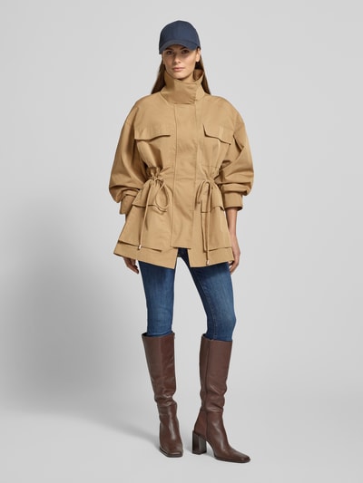 Kobiece model prezentuje Jacke mit Stehkragen und Pattentaschen od Jake*s Casual w kolorze beżowym, z bawełnianego miksu, widok całej sylwetki z przodu.