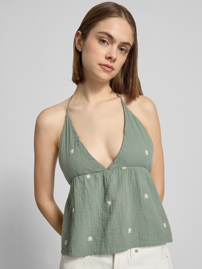 Frauenmodel trägt Crop Top aus reiner Baumwolle Modell 'THYRA RIO' von Only, Optik: Unifarben, Stickerei, Regular-Fit, Neckholder, V-Ausschnitt, Rückenfrei, Ganzkörperansicht von vorne.
