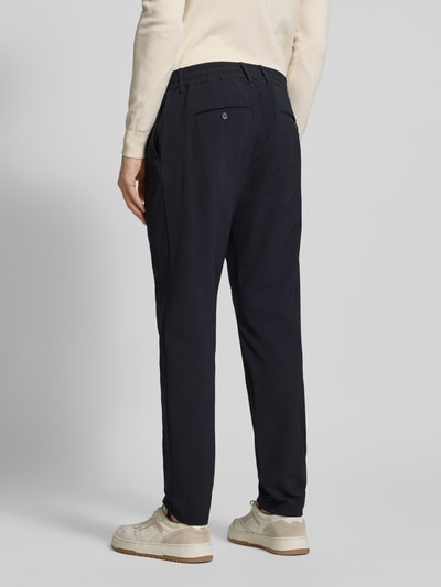 Męski model nosi Slim Fit Stoffhose mit Strukturmuster od CRUNA, elastyczna mieszanka materiałów, krój slim fit, fakturowany wzór, kieszenie z tyłu i wpuszczane kieszenie, elastyczny pas, szerokość w rozmiarze 50: 44 cm, długość wewnętrzna nogawki w rozmiarze 50: 79 cm, kolor ciemny, gładka powierzchnia, całkowity widok z tyłu.