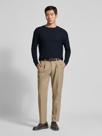 Männermodel trägt Slim Fit Pullover in Strick-Optik von ARMANI EXCHANGE in Dunkelblau aus reiner Baumwolle, Ganzkörperansicht von vorne.
