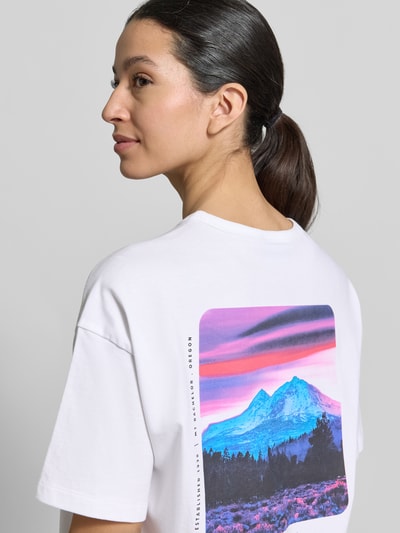 Modelka prezentuje damski t-shirt z bawełny od Columbia, model 'CSC™' z nadrukiem z logo, luźny krój, okrągły dekolt, tył 60 cm, widok z tyłu