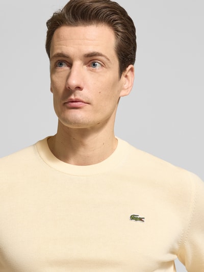 Männermodel trägt Regular Fit Strickpullover aus Baumwoll-Mix von Lacoste, Optik: Unifarben, Materialverarbeitung: Strick, Nahaufnahme Oberkörper.