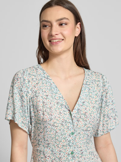 Frauenmodel trägt Minikleid aus reiner Viskose Modell 'EVIDA' von Only mit Allover-Muster und V-Ausschnitt, Nahaufnahme Oberkörper.