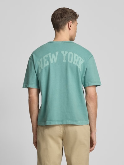 Männermodel trägt T-Shirt mit Logo und Rundhalsausschnitt von GAP, Herren T-Shirt aus Reine Baumwolle, Regular-Fit, Rückenlänge 61 cm, Ganzkörperansicht Rückansicht.