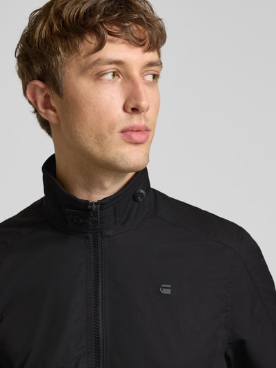 Männermodel trägt Jacke mit Stehkragen und Reißverschluss von G-Star Raw in Schwarz, Baumwoll-Mix, Nahaufnahme Oberkörper.