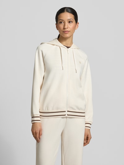 Frauenmodel trägt Regular Fit Sweatjacke aus Viskose-Mix mit Logo-Stitching von ARMANI EXCHANGE in Beige mit Reißverschluss, Kapuze und elastischen Abschlüssen, Ganzkörperansicht von vorne.