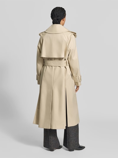 Frauenmodel trägt Trenchcoat aus reiner Baumwolle von Victoria Beckham in Beige mit Umlegekragen und Tallienband, Ganzkörperansicht Rückansicht.