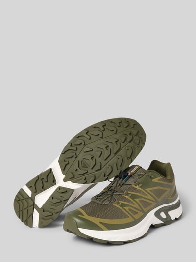 Produktfoto, Sneaker mit profilierter Sohle Modell 'XT-EVR' von Salomon in Olivgrün mit Schnürung und Logo, Sohlen- und Seitenansicht, abgerundete Spitze, strukturierte Textur, Absatzhöhe 4 cm, Schafthöhe 7 cm, Schaftweite 8 cm