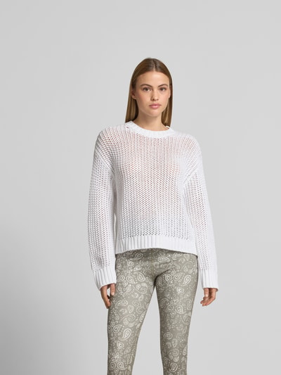 Frauenmodel trägt Sweatshirt in Loch-Strick-Optik von Juvia in Weiß mit rundem Ausschnitt und semitransparentem Baumwoll-Mix, Ganzkörperansicht von vorne.