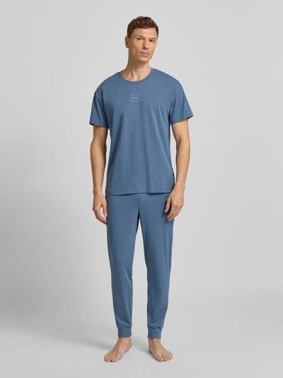 Männermodel trägt Regular Fit Sweathose aus Baumwoll-Mix Modell 'LAZE' von HUGO in Blau, unifarben, Ganzkörperansicht von vorne.