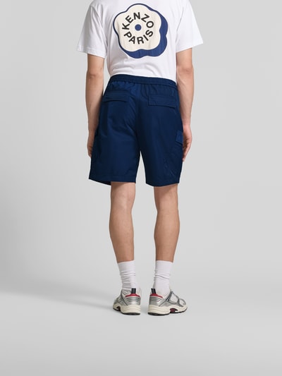 Männermodel trägt Regular Fit Shorts mit Cargotaschen von Kenzo in Dunkelblau, elastischer Bund mit Tunnelzug, Gesäßtaschen, Ganzkörperansicht Rückansicht.