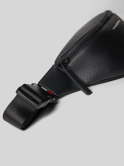 Produktfoto, Bauchtasche mit Strukturmuster von Tommy Hilfiger aus robustem Material mit Hauptfach, Reißverschluss, Klickverschluss, Label-Schriftzug, Logo-Details, Reißverschlussfach innen, verstellbarer Schulterriemen, Maße: 36 cm breit, 15 cm lang, 5 cm tief, Schulterriemen 90 cm.