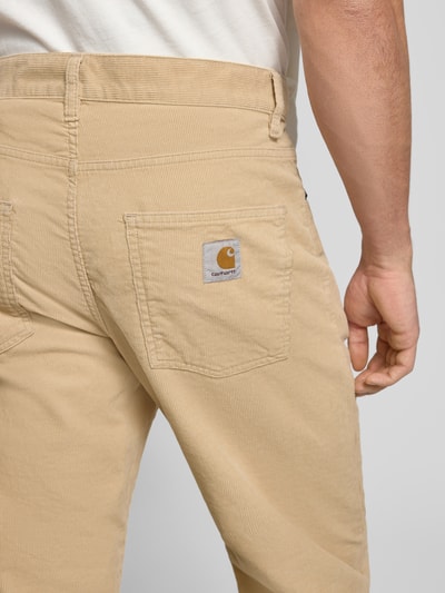 Männermodel trägt Stoffhose mit 5-Pocket-Design von Carhartt Work In Progress aus reiner Baumwolle, gerader Schnitt, Detailaufnahme Rückansicht.