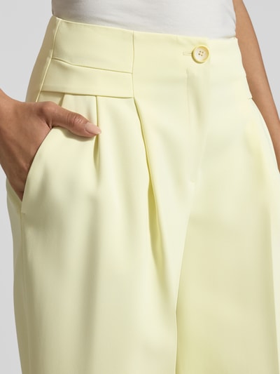 Kobiece modelka nosi Wide Fit Stoffhose mit Bügelfalten od Marc Cain, mieszanka materiałów z dodatkiem stretchu, wysoki stan, szerokość w rozmiarze 36: 40 cm, długość nogawki od wewnątrz w rozmiarze 36: 81 cm, jasny żółty kolor, faktura gładka, zbliżenie na górną część ciała
