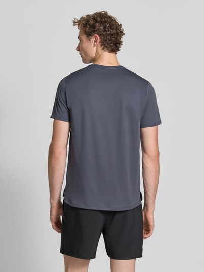 Męski model nosi T-Shirt mit Logo-Print Model 'CORE' od ASICS TIGER w kolorze grafitowym, prosty krój, okrągły dekolt, Długość tyłu w rozmiarze M: 72 cm, Ganzkörperansicht Rückansicht.