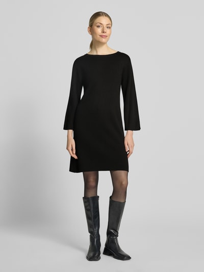 Modelka kobieca nosi czarną sukienkę mini Regular Fit Minikleid aus Viskose-Mix od MORE, dekolt w łódkę, rękaw o dł. 3/4, Długość tyłu 87 cm, Szerokość w rozmiarze 42 cm, Długość rękawów 51 cm, Mieszanka wiskozy, Ganzkörperansicht von vorne.