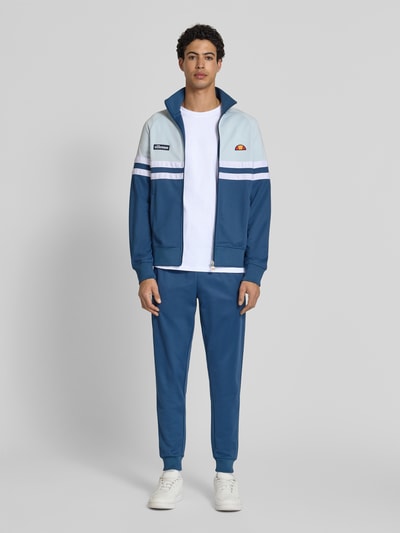 Męski model nosi T-Shirt mit Label-Stitching Modell 'CASSICA' von Ellesse z bawełny, prosty krój, okrągły dekolt, długość tyłu 71 cm, Ganzkörperansicht von vorne.