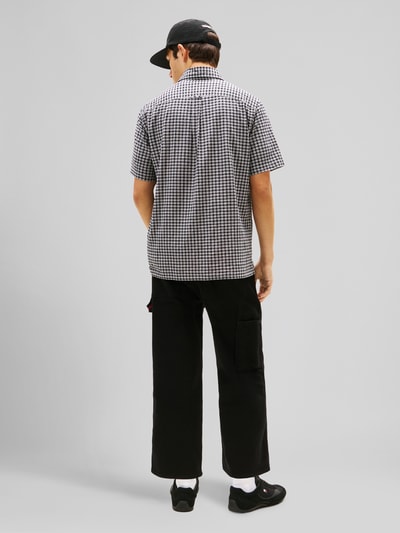 Männermodel trägt Regular Fit Freizeithemd aus Baumwoll-Mix von Tommy Jeans mit Allover-Muster, Kentkragen, Logo-Stitching, Ganzkörperansicht Rückansicht.
