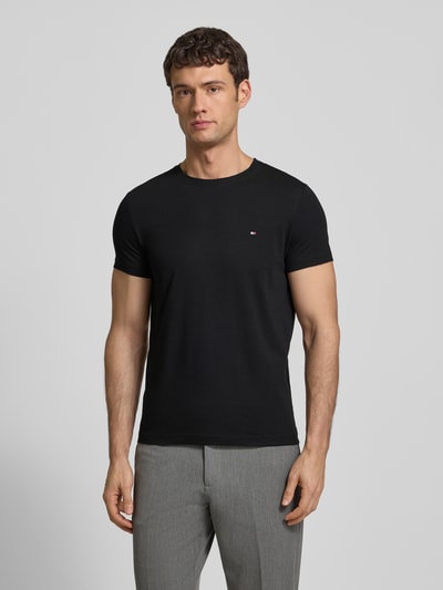 Männermodel draagt Slim Fit T-shirt met ronde hals van Tommy Hilfiger, mix van katoen en elastaan, geborduurd logo, ruglengte 69 cm, slim fit, Ganzkörperansicht von voren.