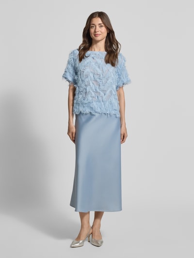 Kobiece model prezentuje Relaxed Fit Bluse mit Fransen Modell 'MYLINE' od Selected Femme, jasnoniebieski kolor, krótki rękaw, półprzezroczysty element, dekolt typu łódka, jednolity wzór, krój relaxed fit, przód całości