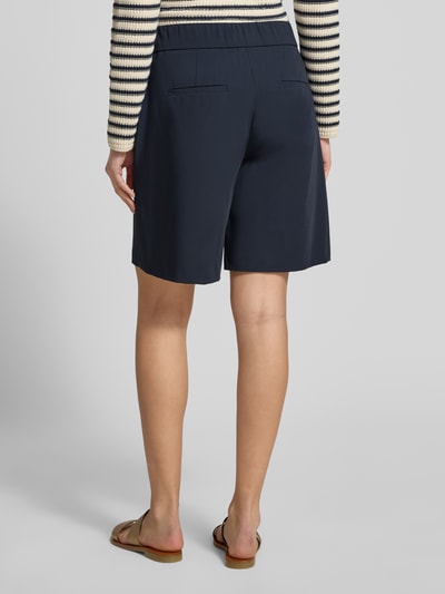Modelka kobieca nosi Schlupfbermuda Techno Cotton Superstretch od Raffaello Rossi, kolor granatowy, krój regular fit, elastyczny pas, kieszenie z tyłu, szerokość w rozmiarze 36: 39 cm, długość nogawki wewnętrznej: 24 cm, widok całej sylwetki z tyłu.