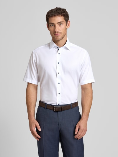 Männermodel trägt Regular Fit Business-Hemd aus Baumwolle mit Kentkragen von ETERNA, weiß, Knopfleiste, 1/2-Arm, Ganzkörperansicht von vorne. Rückenlänge 80 cm, Schulterbreite 45 cm, Ärmellänge 28 cm bei Größe 40.