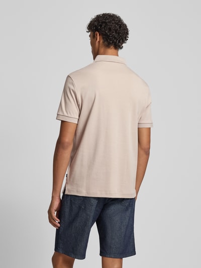 Männermodel trägt Modern Fit Poloshirt mit Logo-Stitching Modell 'Primo' von JOOP! Collection in Beige, Kurzarm, Rückansicht, Ganzkörperansicht.