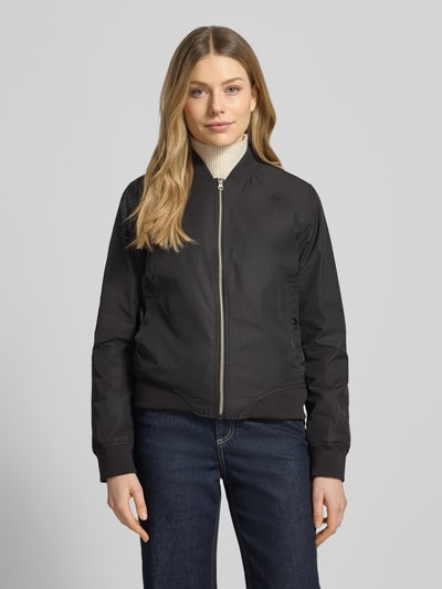 Frauenmodel trägt Regular Fit Jacke mit Stehkragen Modell 'Zaymi' von CARS JEANS, schwarz, Reißverschluss, Eingrifftaschen, elastische Abschlüsse, Ganzkörperansicht von vorne. Rückenlänge 61 cm, Schulterbreite 41 cm, Brustweite 39 cm, Ärmellänge 60 cm.