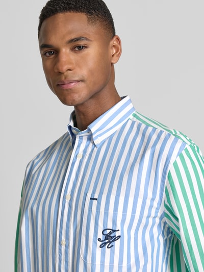 Männermodel trägt Regular Fit vrijetijdsoverhemd van Tommy Hilfiger met all-over motief, kentkraag, gestikt logo, puur katoen, fijne geweven structuur, knoopsluiting, lange mouw met manchet, close-up bovenlichaam.