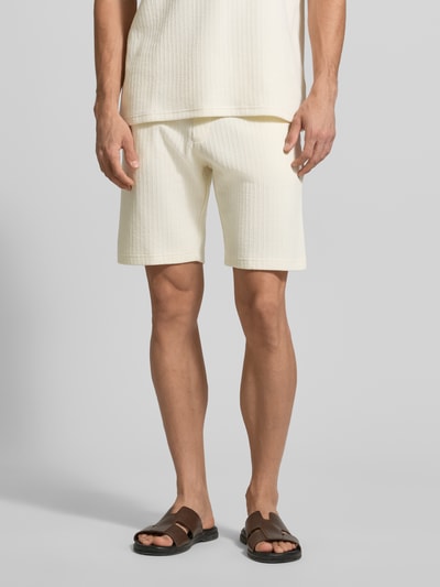 Mannenmodel draagt Regular Fit Shorts met tunnelkoord van MCNEAL in crème, katoenmix met stretch, steekzakken, achterzak, regular fit, binnenbeenlengte 23 cm, bandwijdte 43 cm. Ganzebodyvooraanzicht.