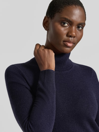 Frauenmodel trägt Regular Fit Rollkragenpullover aus reinem Kaschmir von Christian Berg Woman in Dunkelblau, weiche Textur, Nahaufnahme Oberkörper.