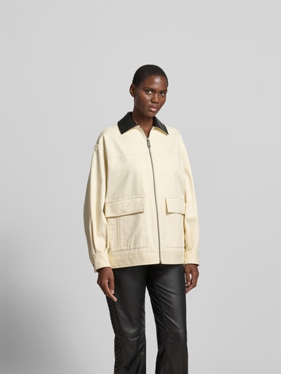 Frauenmodel trägt Relaxed Fit Jacke mit Umlegekragen von Anine Bing aus Reine Baumwolle, cremefarben mit Aufgesetzte Taschen und Reißverschluss, Rückenlänge 70 cm, Brustweite 59 cm, Ärmellänge 55 cm, Ganzkörperansicht von vorne.