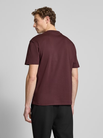 Mannelijk model draagt Regular Fit T-Shirt uit pure katoen model 'DALILE' van HUGO, effen bordeaux, label patch, kortemouw, achterkant volledig zichtbaar, Ganzkörperansicht Rückansicht.