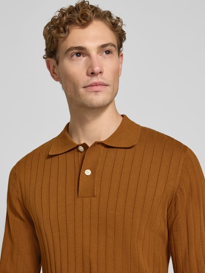Männermodel trägt Regular Fit Poloshirt aus reiner Baumwolle Modell 'TORINO' von Selected in Braun mit Rippenstruktur, Nahaufnahme Oberkörper.