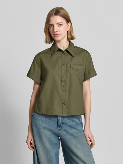 Frauenmodel trägt Boxy Fit Bluse mit Brusttasche von Luisa Cerano in Olivgrün, reine Baumwolle, Hemdblusenkragen, Knopfleiste, Ganzkörperansicht von vorne.
