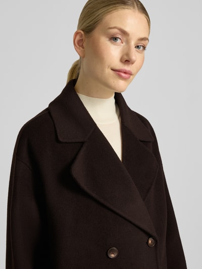 Kobiece modelka nosi Relaxed Fit Mantel aus reiner Wolle mit 2-Knopfleiste von Milano Italy, ciemnobrązowy, Kołnierz z połami, wpuszczane kieszenie, krój relaxed fit, Długość tyłu w rozmiarze 36: 115 cm, Szerokość ramion w rozmiarze 36: 45 cm, Szerokość klatki piersiowej w rozmiarze 36: 56 cm, Długość rękawów: 55 cm, zbliżenie na górną część ciała.