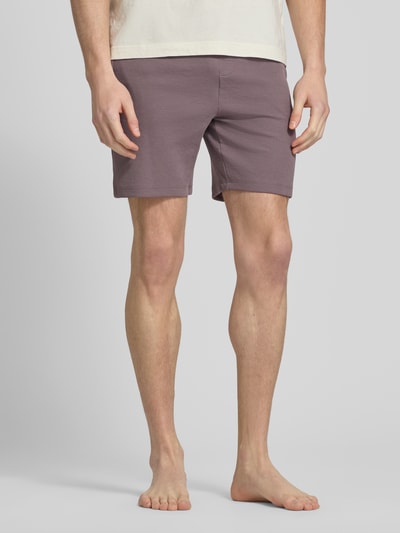 Mannenmodel draagt Regular Fit Sweatshorts aus Baumwoll-Mix van BOSS in effen kleuren met wafelstructuur, katoenmix, zij-steekzakken, tunnelkoord en elastisch pijpboord. Ganzkörperansicht van voren.