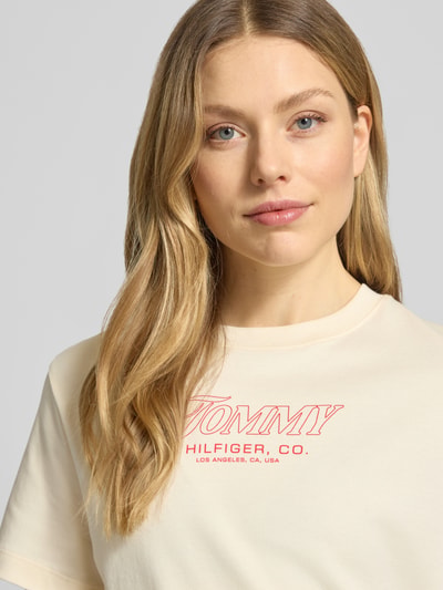 Vrouwenmodel draagt Slim Fit T-shirt uit puur katoen van Tommy Hilfiger met look: effen kleuren, labelprint, ronde hals, korte mouw, jersey. Nahaufnahme bovenlichaam.