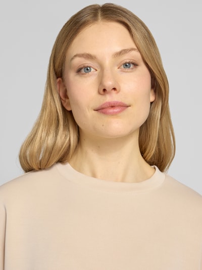 Frauenmodel trägt Sweatshirt aus Modal-Mix mit Kappärmeln von Rich & Royal in Beige, Relaxed-Fit, Rundhalsausschnitt, Nahaufnahme Oberkörper.