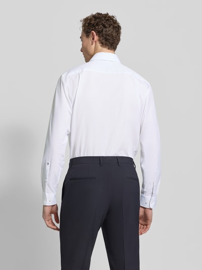 Männermodel trägt Regular Fit Business-Hemd mit Kentkragen von SEIDENSTICKER aus reiner Baumwolle, weiß, glatte Textur, Ganzkörperansicht Rückansicht.