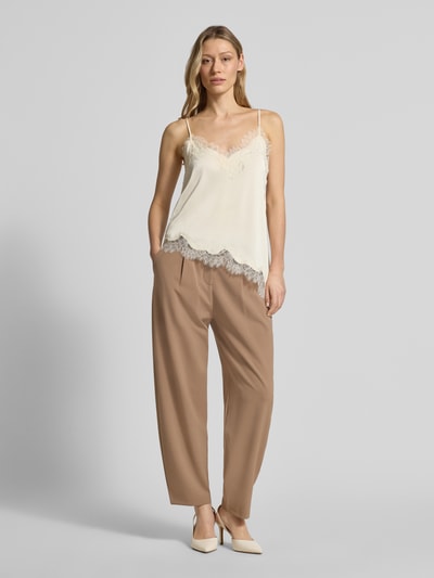 Frauenmodel trägt Wide Fit Stoffhose mit Schurwoll-Anteil Modell 'Megan' von Brax in Beige, elastischer Material-Mix, Bundfalten, Ganzkörperansicht von vorne.